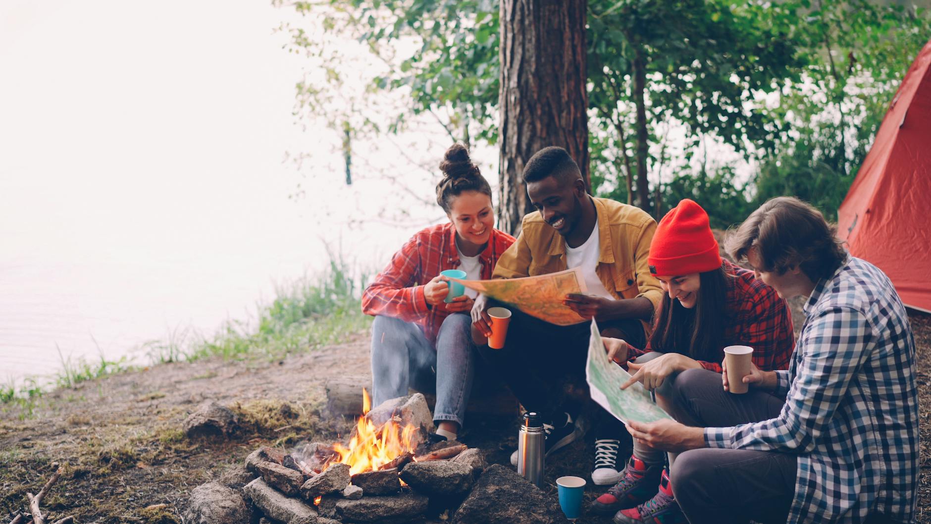 Junge Menschen am Lagerfeuer am See
